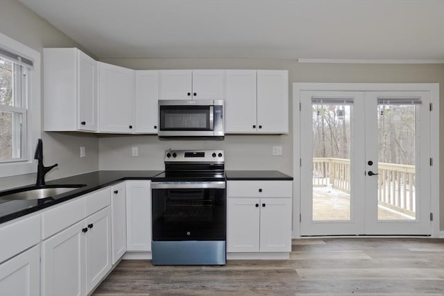 kitchen with stainless steel appliances, sink, white cabinets, and french doors