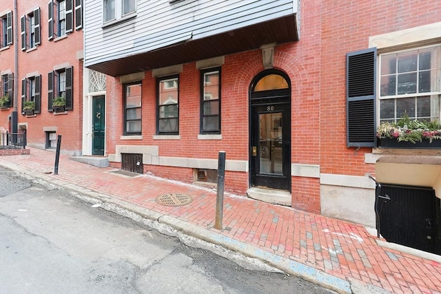 doorway to property featuring brick siding