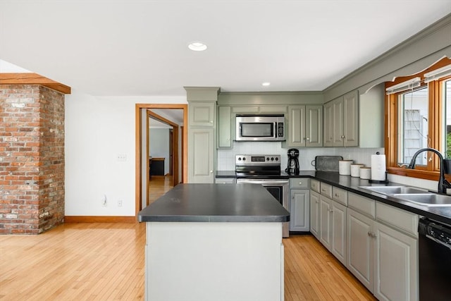 6 Paddock Dr, Harwich, MA 02645 - kitchen featuring appliances with stainless steel finishes, light wood-style flooring, dark countertops, a kitchen island, and tasteful backsplash