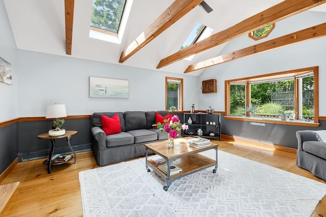 6 Paddock Dr, Harwich, MA 02645 - living room featuring wood finished floors, beamed ceiling, a baseboard radiator, plenty of natural light, and a skylight
