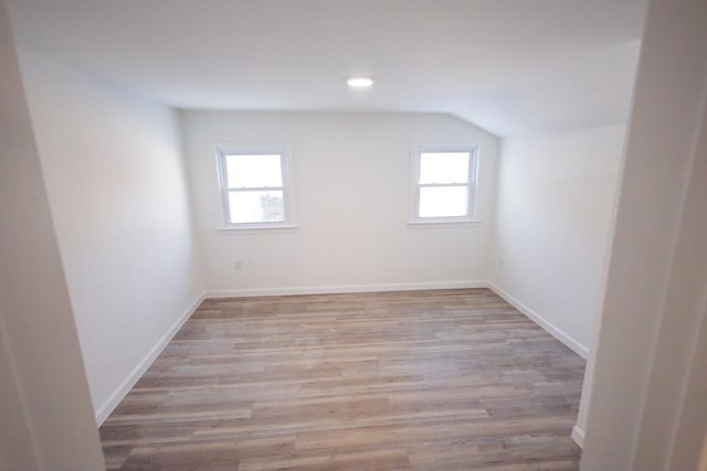 empty room featuring lofted ceiling and light wood-type flooring