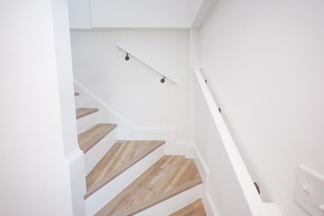 stairs featuring hardwood / wood-style flooring