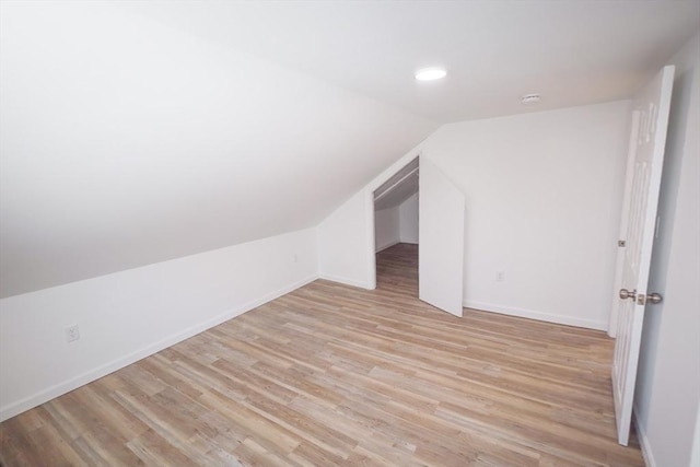 bonus room with lofted ceiling and light wood-type flooring