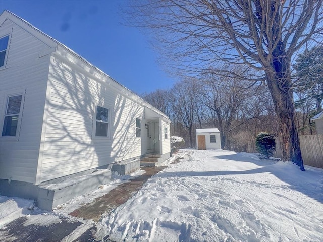 view of snow covered exterior featuring a storage unit