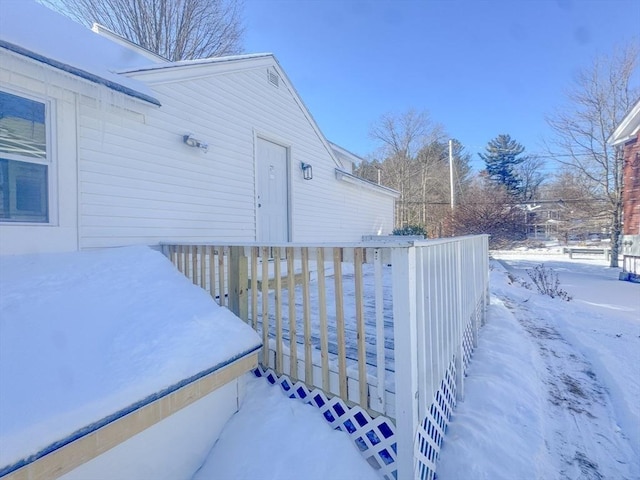 view of snowy exterior featuring a deck