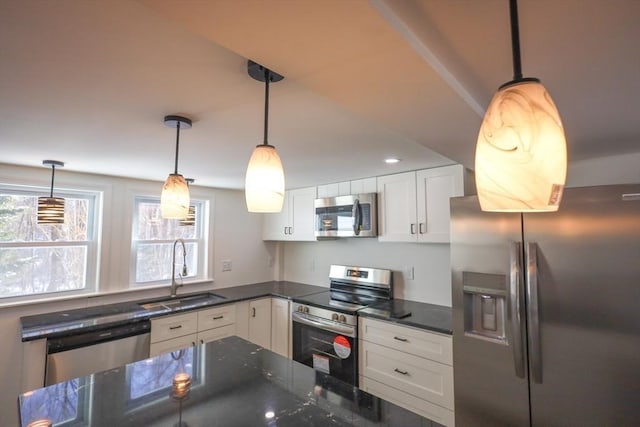 kitchen with white cabinetry, appliances with stainless steel finishes, sink, and pendant lighting