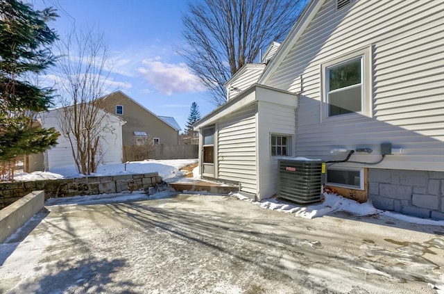 view of snow covered exterior with central AC