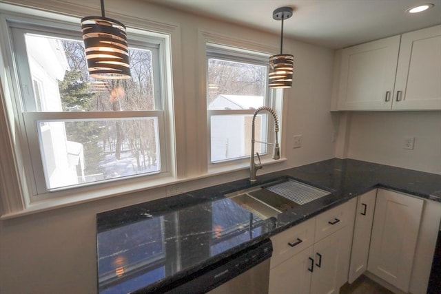 kitchen featuring white cabinetry, dark stone counters, and decorative light fixtures