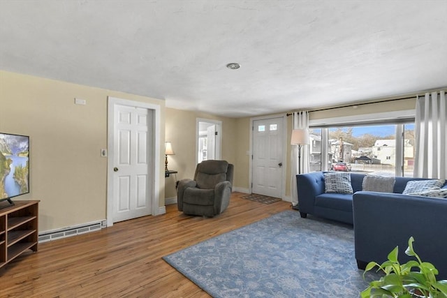 living room with hardwood / wood-style flooring and a baseboard heating unit