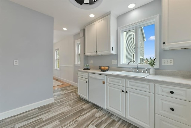 kitchen featuring white cabinetry, light countertops, a sink, and dishwasher