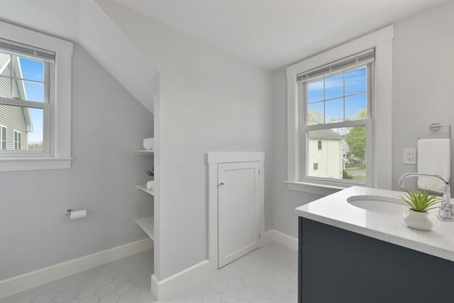 bathroom featuring vanity, baseboards, and a healthy amount of sunlight