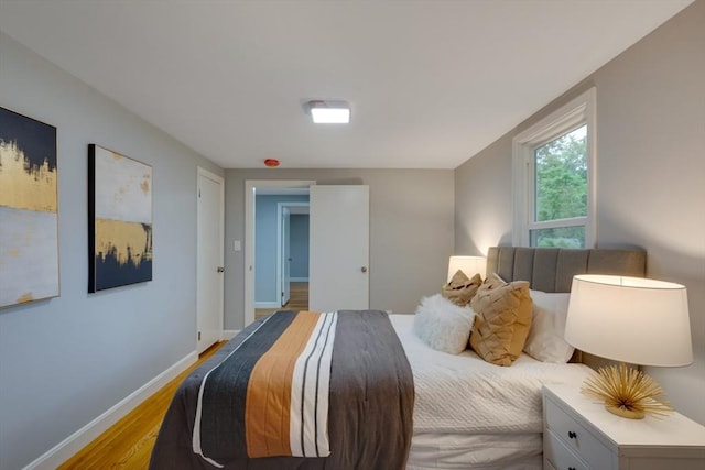bedroom with light wood-style flooring and baseboards