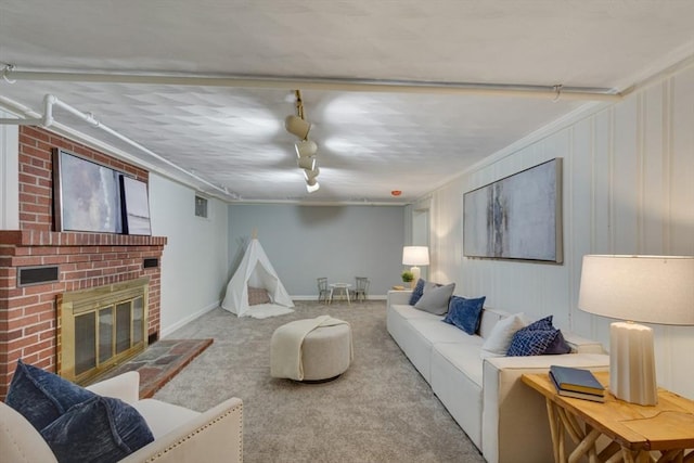 living area featuring a brick fireplace, carpet, and rail lighting