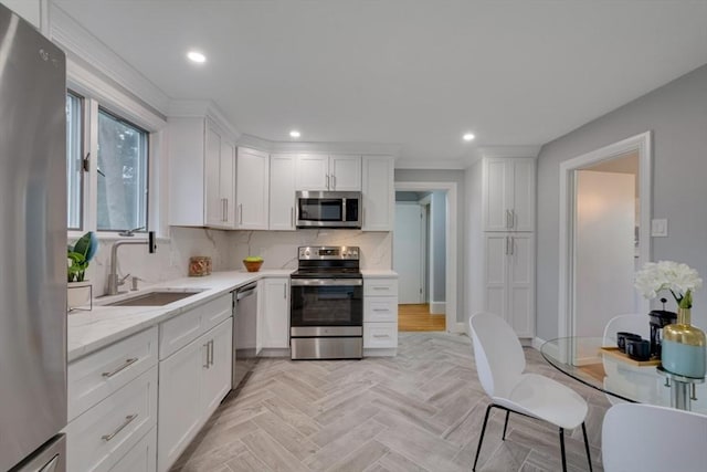 kitchen featuring stainless steel appliances, white cabinets, recessed lighting, and a sink