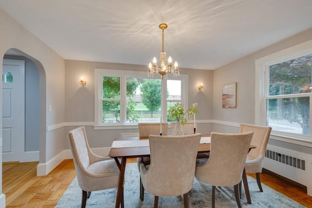 dining area with arched walkways, a notable chandelier, radiator heating unit, and baseboards