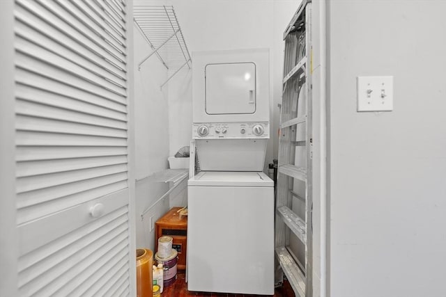 washroom featuring stacked washer and dryer, laundry area, and wood finished floors