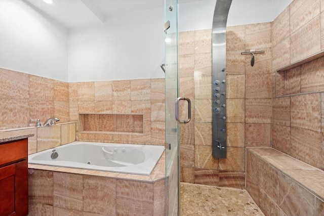 bathroom with vanity, a shower stall, and a tub with jets