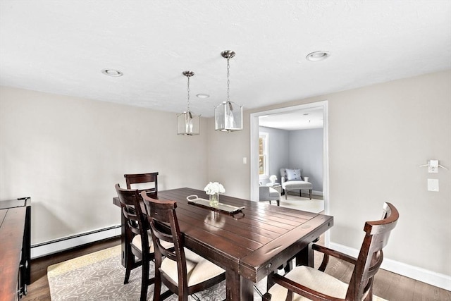 dining room featuring baseboards, baseboard heating, and wood finished floors