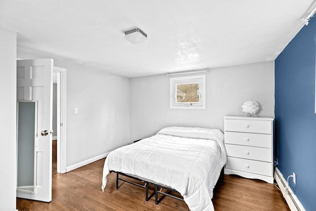 bedroom featuring baseboards, wood finished floors, and baseboard heating
