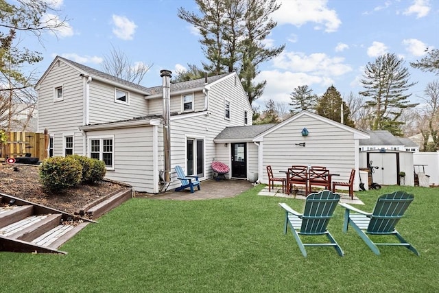 back of property with fence, a lawn, and a patio