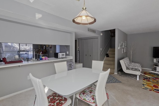 dining area featuring light colored carpet