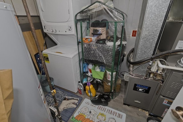 washroom featuring heating unit and stacked washer and dryer