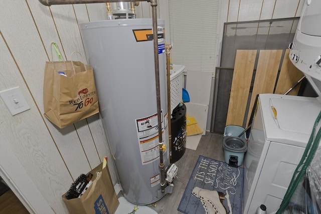 utilities featuring water heater and stacked washer / dryer