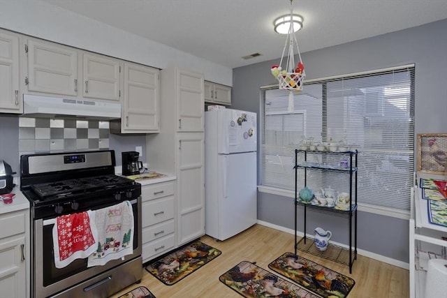 kitchen featuring white cabinets, white fridge, stainless steel gas range, and light hardwood / wood-style flooring