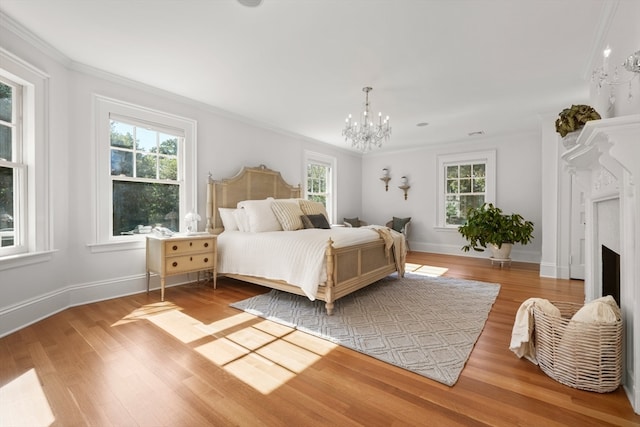 bedroom featuring light wood-type flooring, ornamental molding, and multiple windows