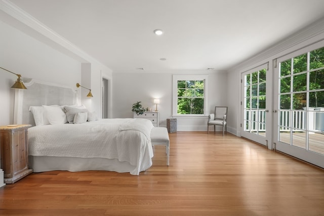 bedroom featuring ornamental molding, light hardwood / wood-style floors, and access to exterior