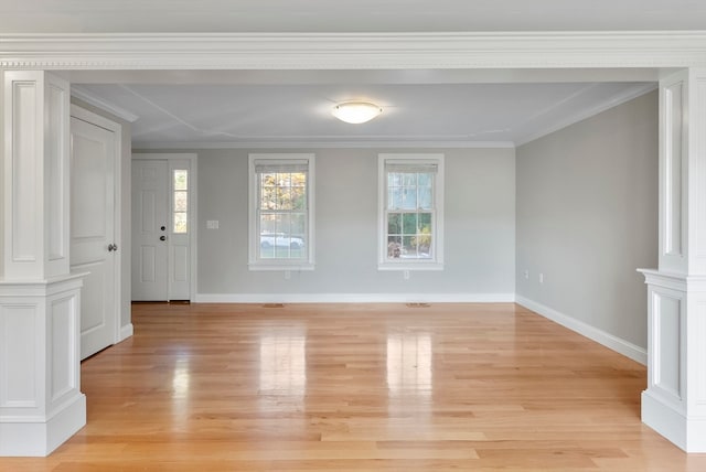 interior space featuring ornate columns, light hardwood / wood-style floors, and crown molding