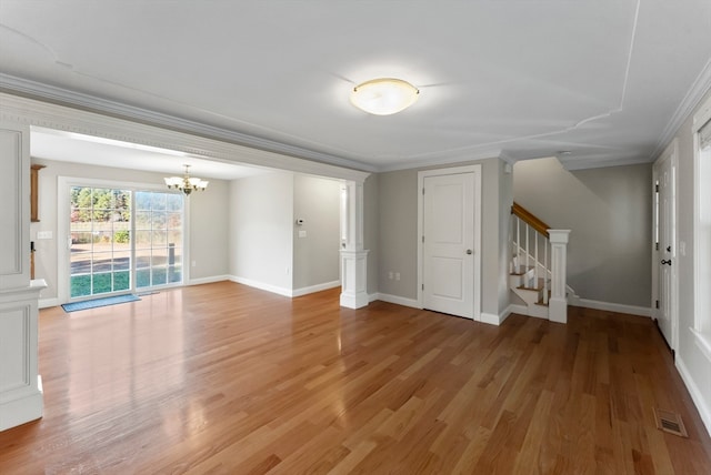 unfurnished living room featuring crown molding, hardwood / wood-style floors, and a notable chandelier