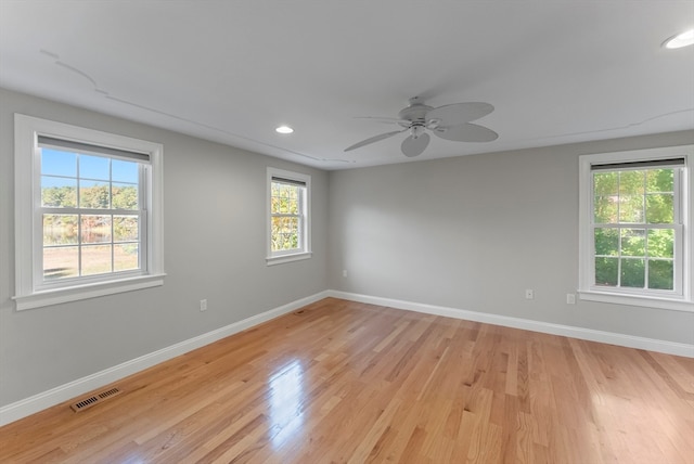 empty room featuring light wood-type flooring, plenty of natural light, and ceiling fan