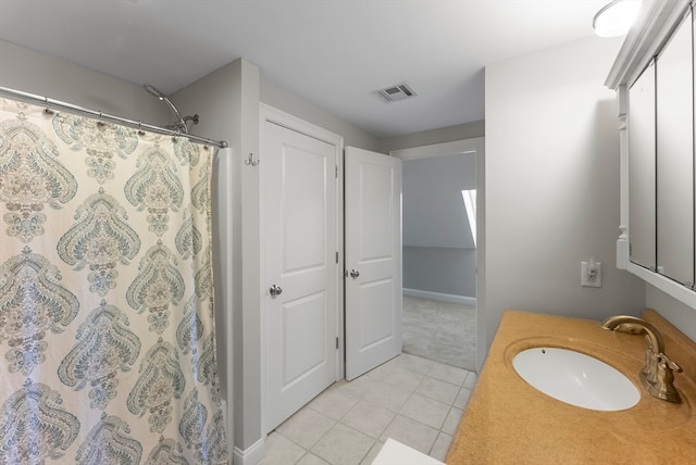 bathroom with walk in shower, vanity, and tile patterned flooring