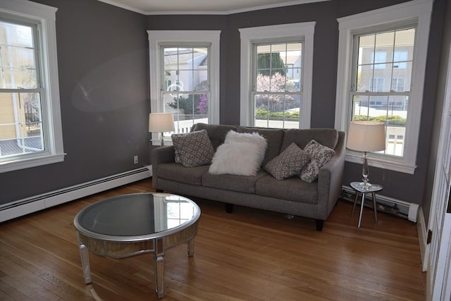 living area featuring a baseboard heating unit, hardwood / wood-style floors, baseboard heating, and ornamental molding