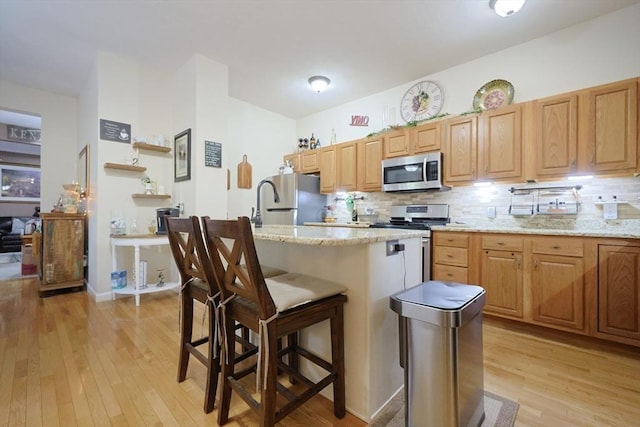 49 Branch St Unit 49, Clinton, MA 01510 - kitchen with stainless steel appliances, light wood-style floors, decorative backsplash, and a breakfast bar