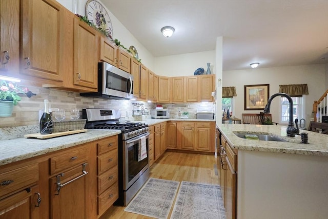 49 Branch St Unit 49, Clinton, MA 01510 - kitchen with appliances with stainless steel finishes, light wood-style flooring, decorative backsplash, and light stone counters