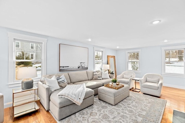 living area featuring plenty of natural light, wood finished floors, and baseboards