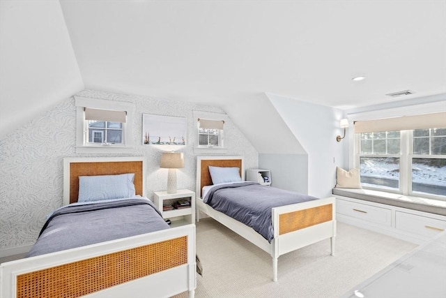 bedroom featuring lofted ceiling, multiple windows, and wallpapered walls