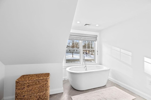 full bath with recessed lighting, visible vents, a freestanding bath, and baseboards