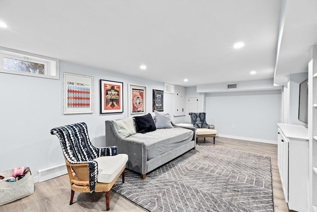 living room with recessed lighting, visible vents, light wood-style flooring, and baseboards