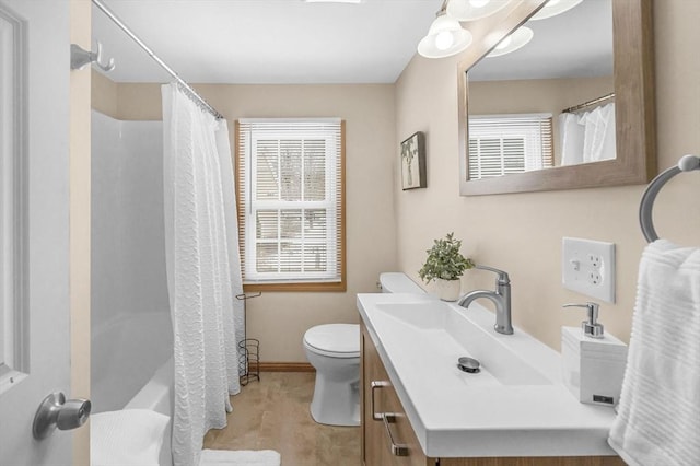 full bathroom with baseboards, vanity, and toilet