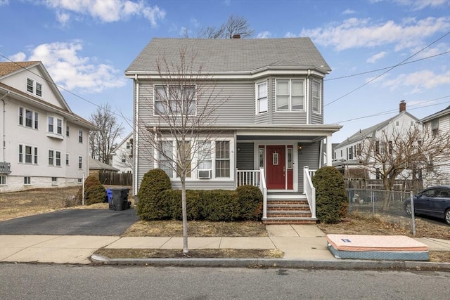 view of front of home with a porch, fence, and aphalt driveway