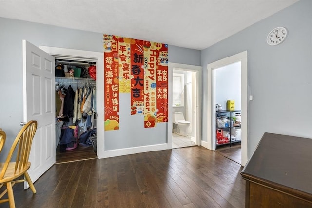 interior space featuring hardwood / wood-style flooring, baseboards, a closet, and connected bathroom