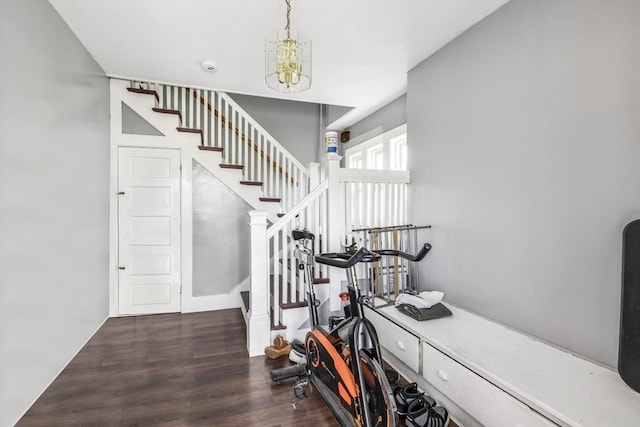 stairs with wood finished floors and a chandelier