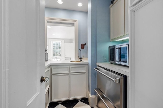 kitchen featuring a sink, stainless steel appliances, and light countertops