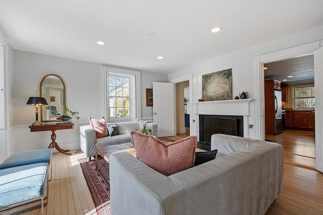 living room with recessed lighting, a fireplace, and hardwood / wood-style flooring