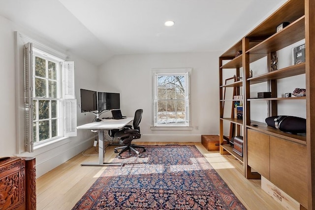 office space with vaulted ceiling, light wood-type flooring, plenty of natural light, and baseboards