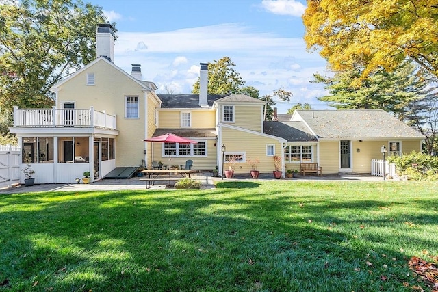 rear view of property with a chimney, fence, a patio, and a yard