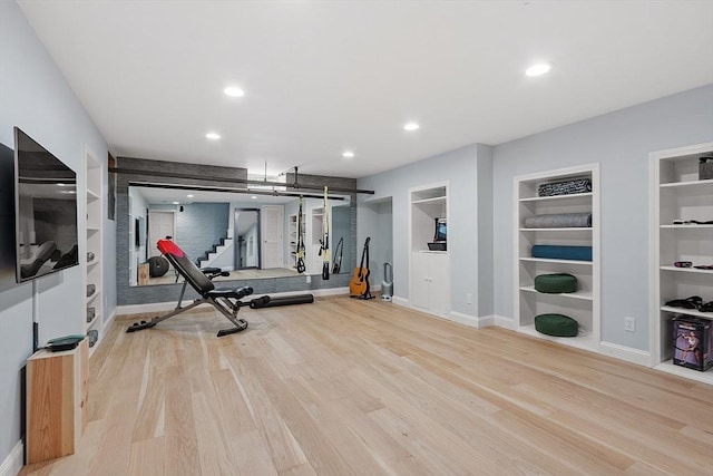 exercise room with baseboards, recessed lighting, wood finished floors, and built in features